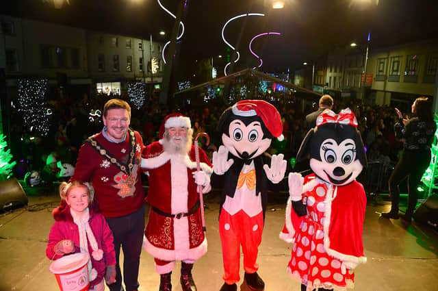 Mayor Councillor Scott Carson and his daughter join Santa, Mickey and Minnie Mouse on the stage at the 2022 Lisburn Christmas Lights Switch-On