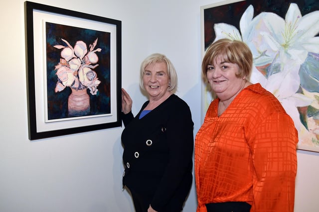 Artist Yvonne Mackle (left) and Millennium Court manager, Geraldine Lawless discuss one of Yvonne's paintings. PT09-243.
