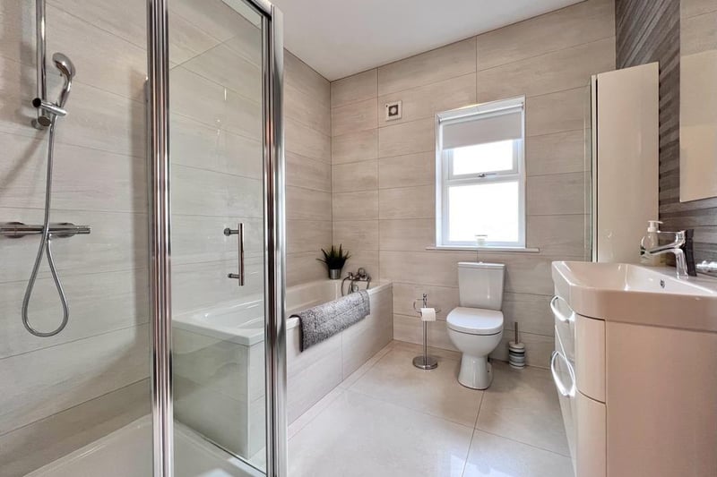 The family bathroom features a WC, wall hung basin and vanity unit, bath, separate mixer shower and towel rail. The walls and floor are fully tiled.