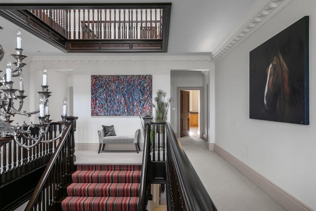 The entrance hall and handcrafted central staircase features a range of bespoke coving and beautiful joinery finishes.