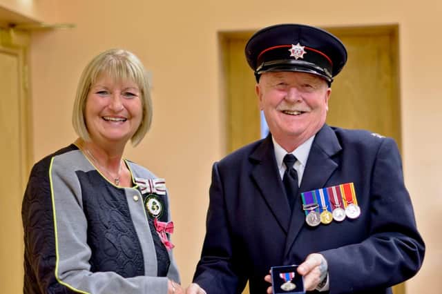 Deputy Lieutenant for Co Antrim, Mrs Jackie Stewart MBE, presents Watch Commander Brian Smith with his Queen's Platinum Jubilee medal.