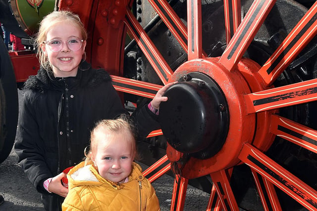 Posing by the massive wheel of a vintage traction engine in the town centre are sisters Elsie (8) and Lily (3) Murray. PT41-215.