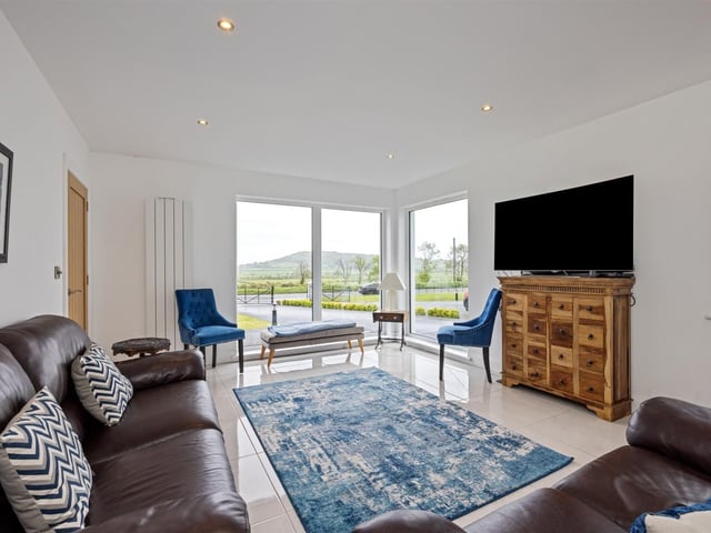 Lounge with feature corner window, enjoying elevated, rural views.