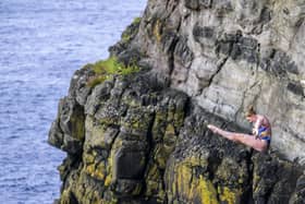 Molly Carlson of Canada dives from the 20.5 metre cliff during the first competition day of the fourth stop of the Red Bull Cliff Diving World Series at Dunluce Castle, Causeway Coast, Northern Ireland on July 18, 2024.