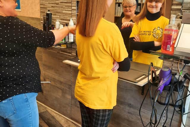 Janice White from Hairforce1in Portadown cutting Lily-Grace Millar's hair  to donate to The Little Princess Trust whilst raising money for Cancer Fund for Children.