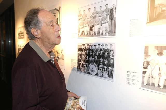 Nelson McGonagle peering at some of the photographs from his new book currently on display in the Roe Valley Arts & Cultural Centre. Credit Causeway Coast and Glens Borough Council