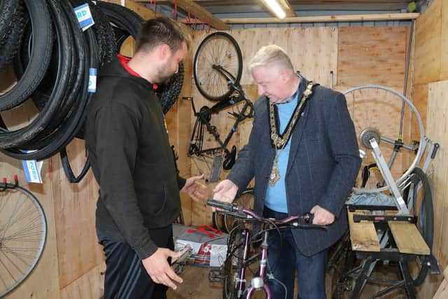 Mayor of Causeway Coast and Glens, Councillor Steven Callaghan is given an overview of how the bicycles are prepared for re-use by Men’s Shed Supervisor Jamie Vinnicombe. Credit Causeway Coast and Glens Borough Council