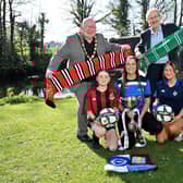 Crusaders Strikers’ Academy players Lexi and Evie, joined by coach Clare, pictured with Councillor Neil Kelly, Mayor of Antrim & Newtownabbey Borough Council, and Budget Energy SuperCupNI Chairperson Victor Leonard, as Manchester United confirm their return to headline the 2025 Girls’ Premier and Junior Sections at this year’s tournament.