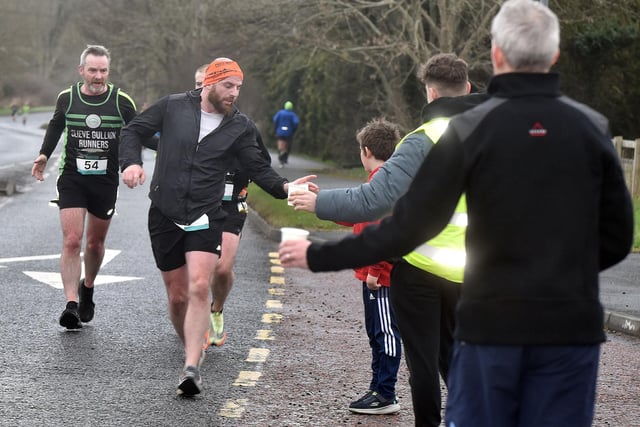 Runners are offered water at the first water stop on the full marathon route. PT11-210.