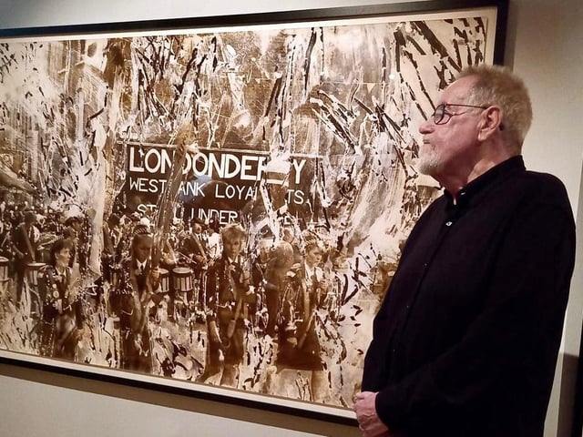Artist and photographer Victor Sloan has been living in Portadown since his marriage to Joy in 1972. Originally from Dungannon, he studied at Belfast and Leeds Colleges of Art, the latter in England. On his return home from England he started lecturing in Lurgan Tech inspiring generations of young artists. Through decades he has captured the life and buildings around the Portadown, Craigavon and Lurgan areas and held numerous exhibitions including recently at the Ulster Museum in Belfast. In 1979 the Vietnamese Boat People came to live in Craigavon. Victor befriended Ka Fue Lay, a teenager from Vietnam. Victor did a series on the Vietnamese Boat People in Craigavon which superbly depicts the reality of its time. Sloan's works are a response to political, social and religious concerns. He is perhaps best known for his works investigating the Orange Order in series such as: Drumming; The Walk, the Platform and the Field and The Birches.