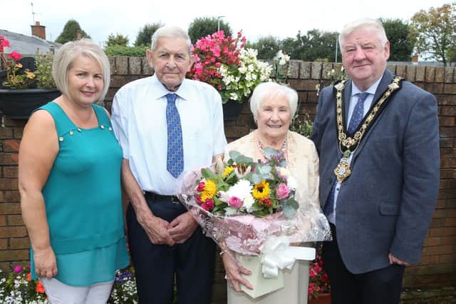 Mayor of Causeway Coast and Glens, Councillor Steven Callaghan presents Sammy and Annie McGregor with a gift to mark their diamond wedding anniversary. Also pictured is daughter Rhonda Thompson. Credit Causeway Coast and Glens Borough Council