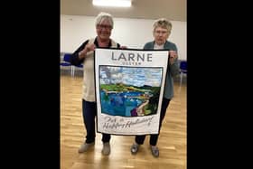 Annie Greenlee and Joan Treacy proudly display the recreation of Norman Wilkinson’s iconic 1930s Larne tourism poster.  Photo: St Cedma's Parish Piecemakers
