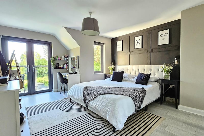Bedroom one with double glazed window to rear aspect, double glazed doors to balcony, radiator, laminate wood floor, and door to en-suite.