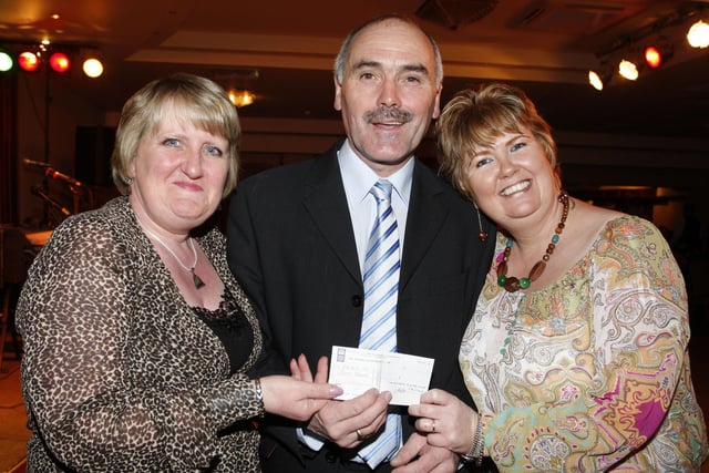 Compere Robert Ramsey presents a cheque to Janet Purcell, manager, and Julie Donnelly, support worker, of Coleraine Blind Centre during the Coleraine Provincial Players concert and fundraising evening at the Lodge Hotel in aid of Coleraine Blind Centre in 2009