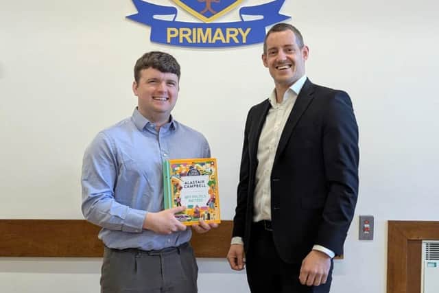 Matthew McMurray (R), a Senior Associate at Pinsent Masons in Belfast, presents new copies of Alastair Campbell’s ‘Why Politics Matters’ book to Dunclug Primary School teacher, Scott Marcus. CREDIT OSCNI