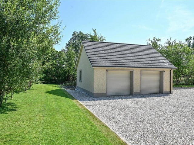 Large detached double garage with automated roller doors, pedestrian access, concrete flooring and electrical supply.