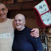Friends Wojtek Bąk and Bernadette Doyle share a hug, after sharing their heads in a stand against cancer.