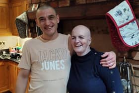 Friends Wojtek Bąk and Bernadette Doyle share a hug, after sharing their heads in a stand against cancer.