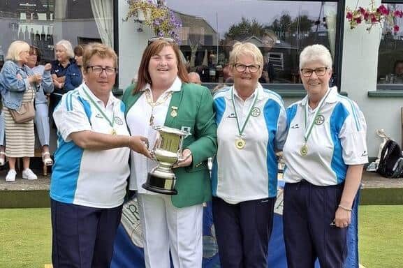 Bernie O'Neill (left) is presented with the trophy for the triples title. Credit Portstewart Bowling Club