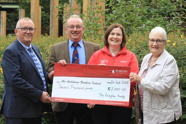 Breige Mulholland, head of operations and finance, Air Ambulance Northern Ireland, receives a cheque for £7,000 from Alex Robinson, Ivan Forsythe and Marian Forsythe. Credit: Julie Hazelton