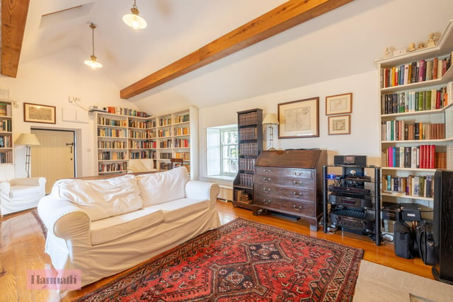 A cosy library and home cinema has been created at ground level in a converted barn.