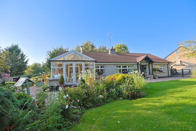 This lovely bungalow has extensive, mature gardens.