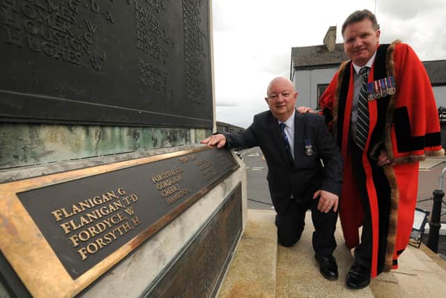 Great War historian and researcher Richard Edgar and Alderman Glenn Barr, with one of three new plaques, added to Banbridge War Memorial, listing new names of local 'Fallen' Great War soldiers. © Photo: Gary Gardiner. C2327521