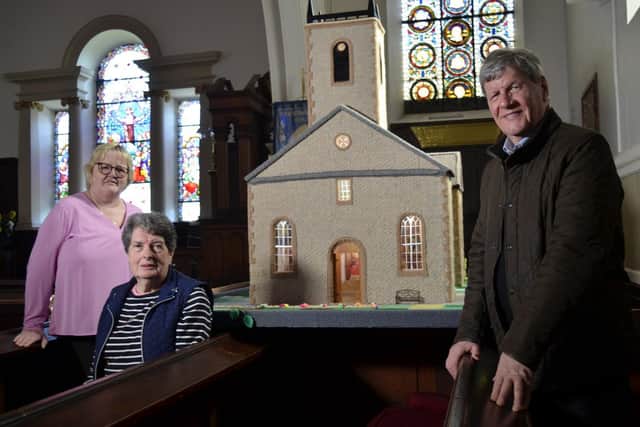 Joyce Stafford and Hilary Keys proudly display the replica of St MacCartan's Cathedral that their group has knitted. Credit: ITV