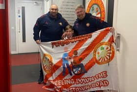 Teenager Kingston Bryars showing off his 'Wheeling down the Brownstown Road' banner to Portadown manager Niall Currie (right) and assistant boss Clifford Adams. Photo by Kingston Bryars.