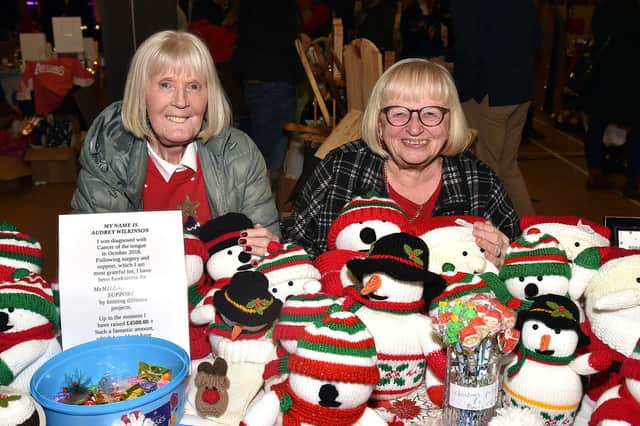 Sister-in-laws, Audrey, left, and Lorraine Wilkinson posing with some of the knitted Christmas figures created by Audrey at the Shankill Parish Christmas Market. The proceeds from sales go to Macmillan Cancer Support. Audrey has raised £4,500 for the charity so far. LM50-211.