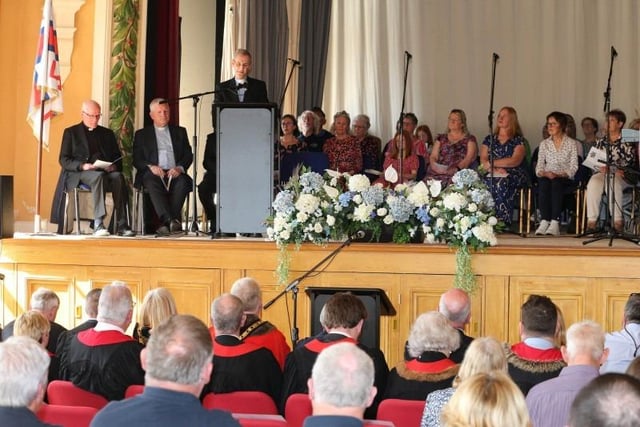 Portrush's community choir Coastal Vocals pictured on stage in Portrush Town Hall with members of the local clergy during the RNLI thanksgiving service.