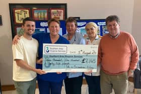 Johnny (left) and his dad John senior (right) are pictured presenting the cheque to hospice staff.