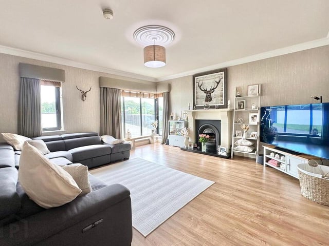 Living room with feature fireplace, laminate wood floor, TV point. Complete with corner window, cornicing and centre rose ceiling moulding.