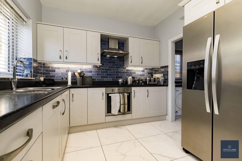 The stylish kitchen has plenty of storage space and is finished with co-ordinating tiled flooring and splashback.