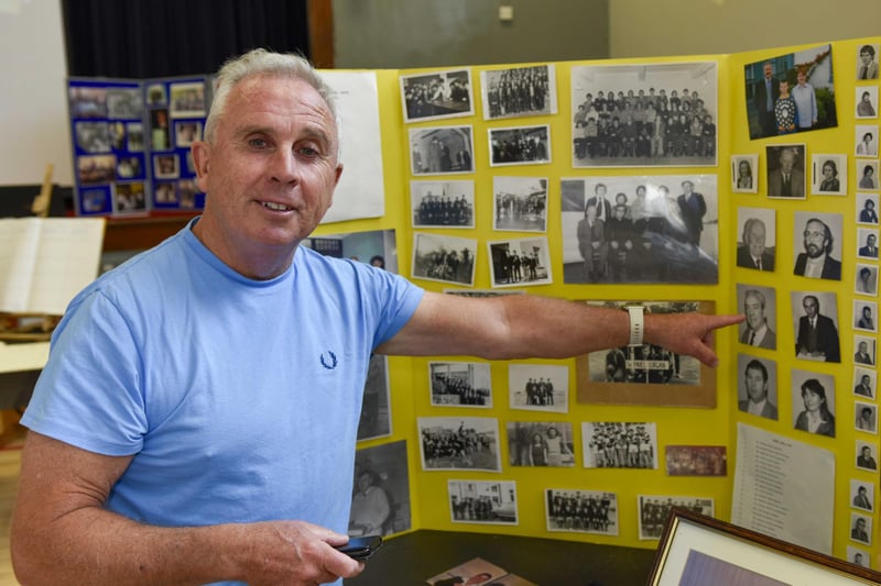 Mr McMorrow points his father Mr John (Sean) McMorrow’s portrait from amongst the alongside other teacher and staff of St Paul’s JHS.