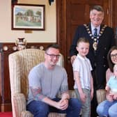 Lewis Rennie (6) and his family at the Mayor's parlour with Alderman Noel Williams.