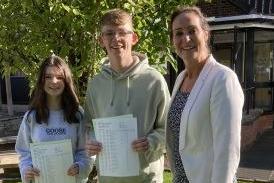 Alice Templepton and Adam Young are congratulated by Principal Dr Rainey on their GCSE examination results.