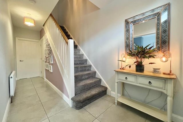 The entrance hall to this lovely home has a practical tiled floor and is decorated in modern neutral tones.