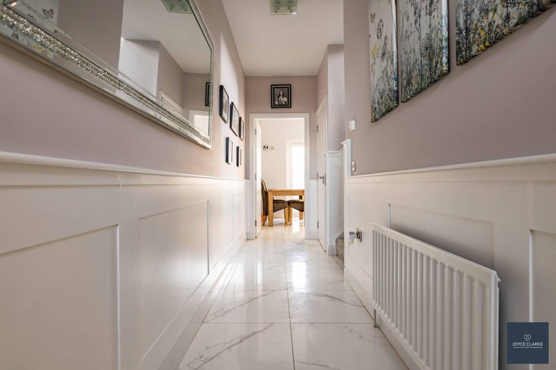 The attractive hallway has feature wall panelling and is stylishly decorated.