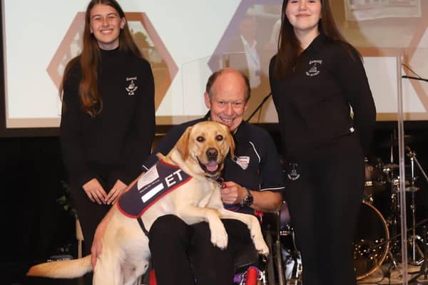 Banbridge HS students Sophia Beacom and Katie Bradley, with 'Hounds for Heroes' founder Allen Parton and assistance dog 'ET'.