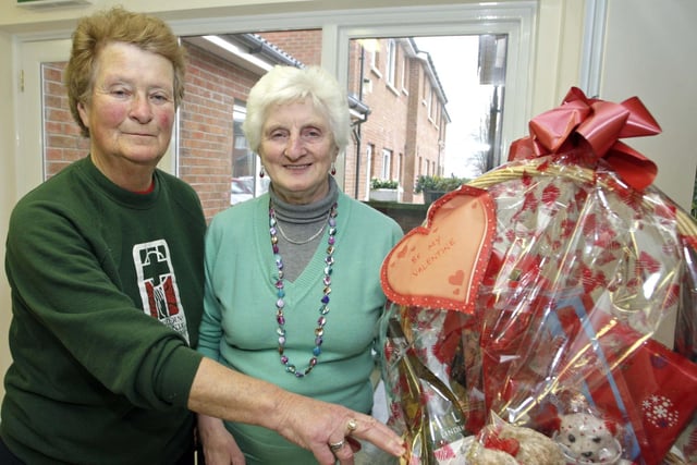 Joan McCaffrey (left), organiser of a Coffee Morning in Shiels Court in 2009 in aid of Ballymoney Hospice Support Group, pictured along with Group treasurer, Annie McFarland and a Valentine's  hamper which was up for grabs in a raffle.