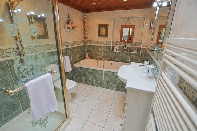 The family bathroom features a bath with telephone style shower attachment, walk-in shower, vanity unit, low flush WC and a towel radiator. The walls and floor are  fully tiled.