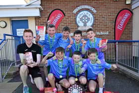 Local pupils from St John’s Primary School, Moy, celebrating their victory at the Flahavan’s Athletics NI prize giving ceremony, receiving their award from Athletics NI Coach, Luke Dinsmore.