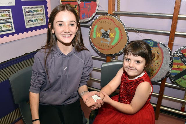 Abigail Ross applies a Christmas tattoo for Maisie Coulter (5) at The Cope Primary School, Loughgall, festive afternoon on Saturday. PT51-213.