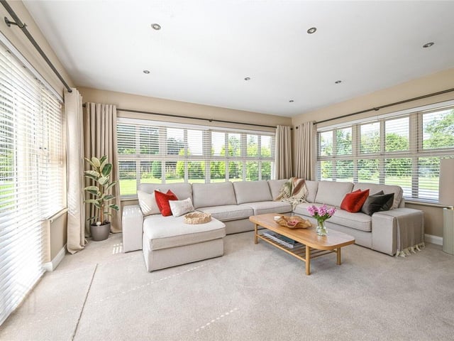 Sunroom with multiple windows capturing the stunning garden and countryside views, and French doors providing access to the rear garden.