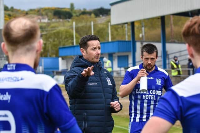 Newry City manager Darren Mullen talks to his players.