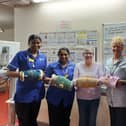 Senior Funeral Director Terry Weir and Dunmurry Crochet Club member Helen Walsh present 10 handmade twiddle muffs to staff at Meadowlands 2, Musgrave Park Hospital, to celebrate the club's tenth anniversary. Pic credit: Terry Weir