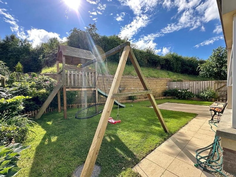 Rear garden fully enclosed with wood fence.