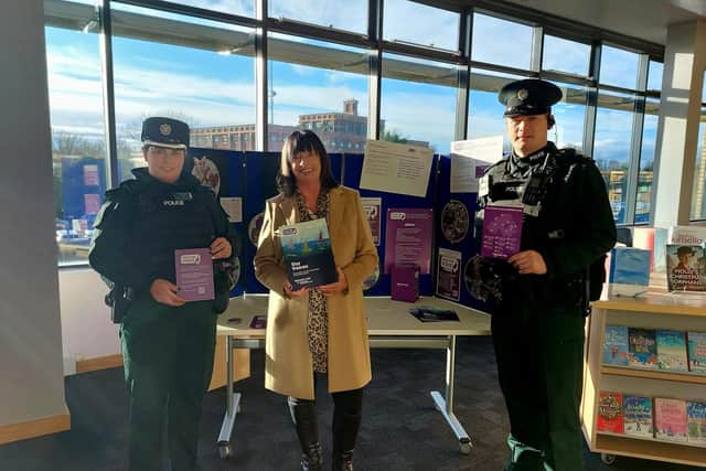Superintendent Julie Mullan, Women's Aid support worker Vicki Kearney, and Inspector Robinson at the Women's Aid display in Lisburn City Library.