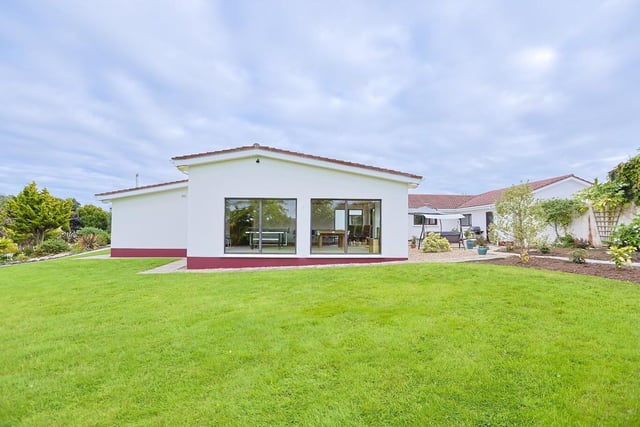 This lovely home is surrounded by stunning landscaped gardens.